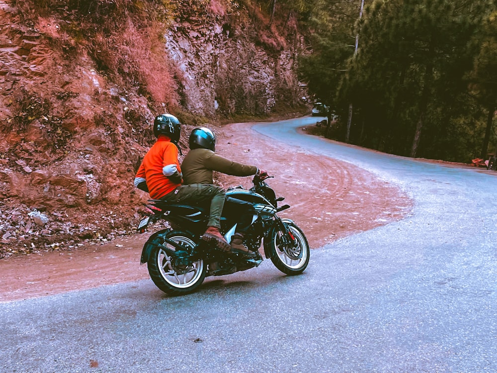 a couple of people riding on the back of a motorcycle