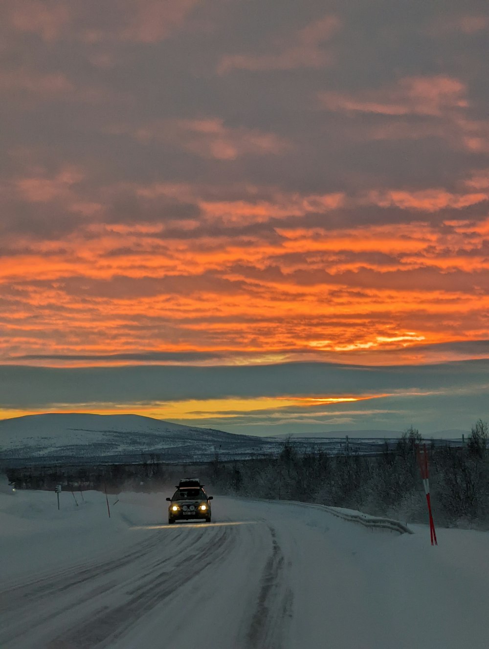 a truck driving down a snow covered road