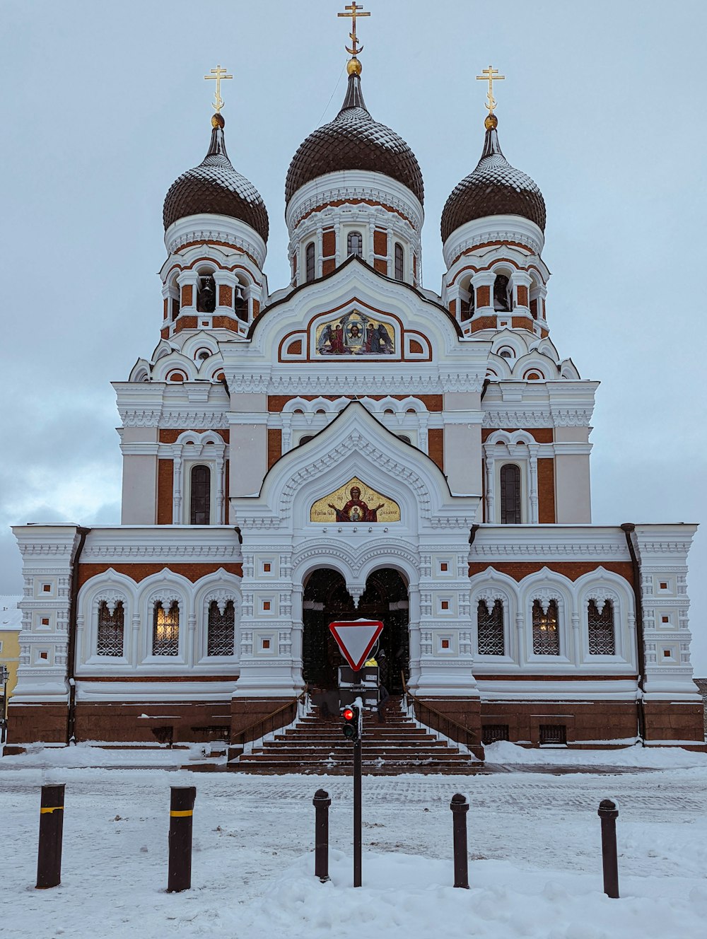 a large white and brown building with a cross on top of it