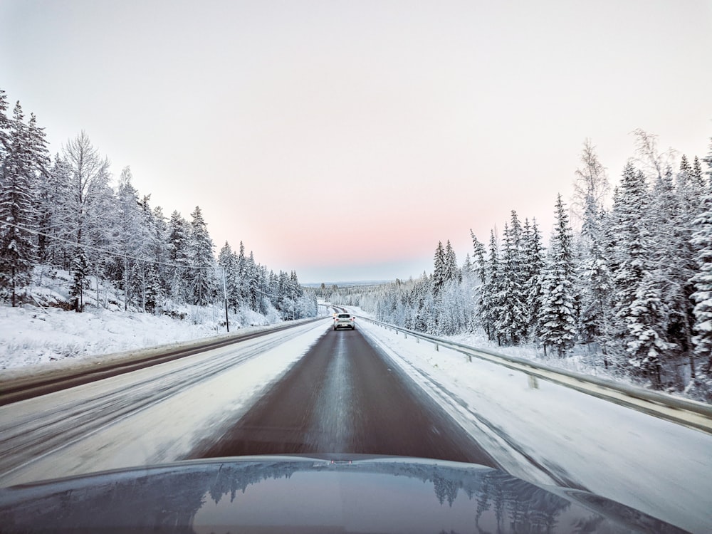 a car driving down a snow covered road