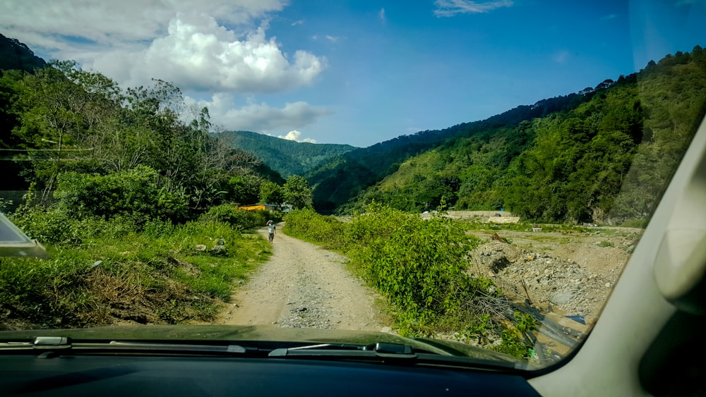 a car driving down a dirt road in the mountains