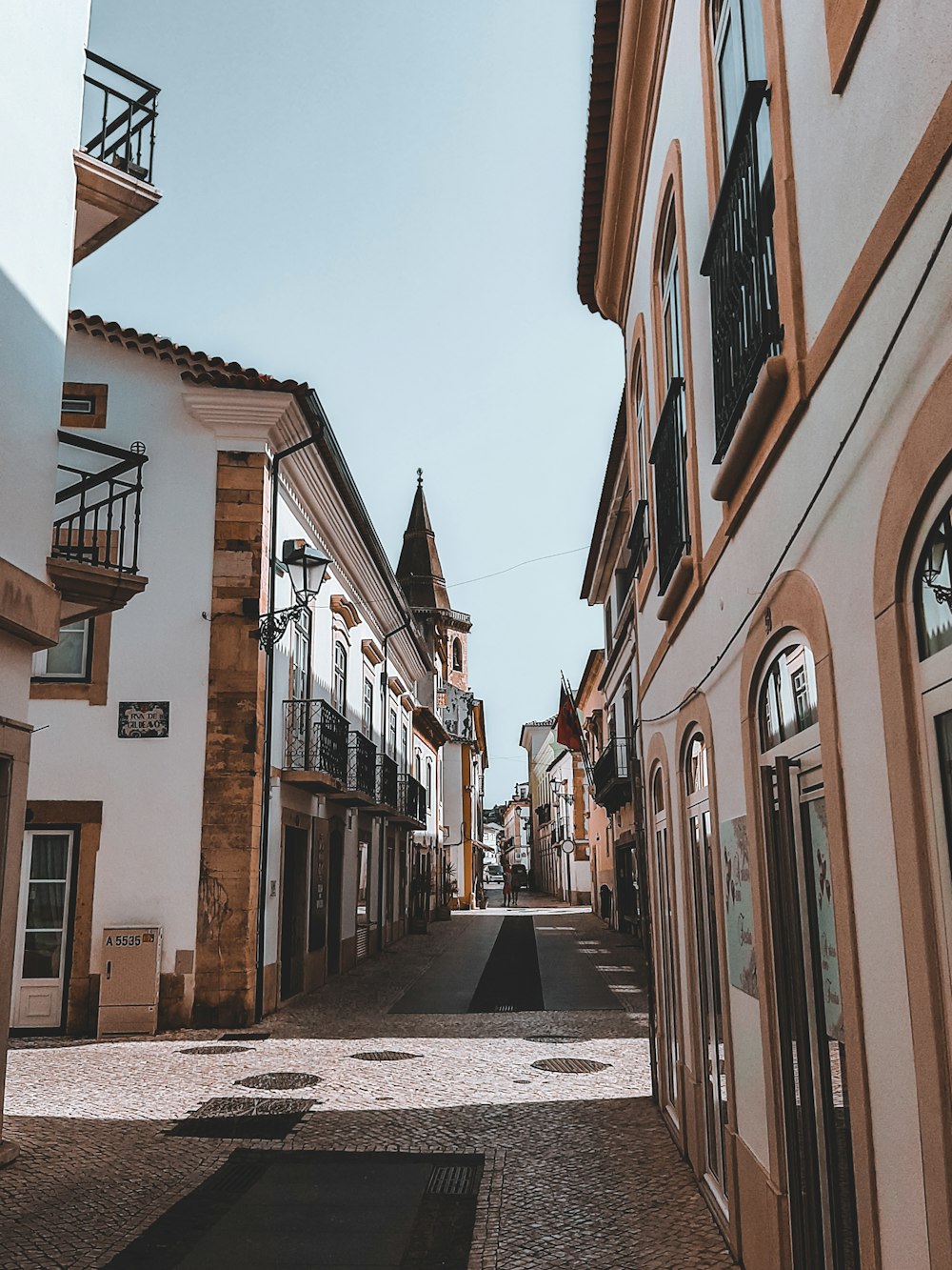 a narrow street lined with buildings and a clock tower