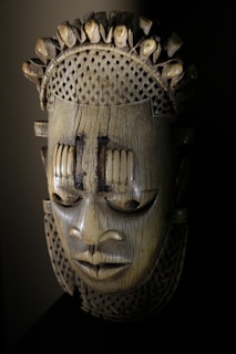 a wooden mask with spikes on it's head