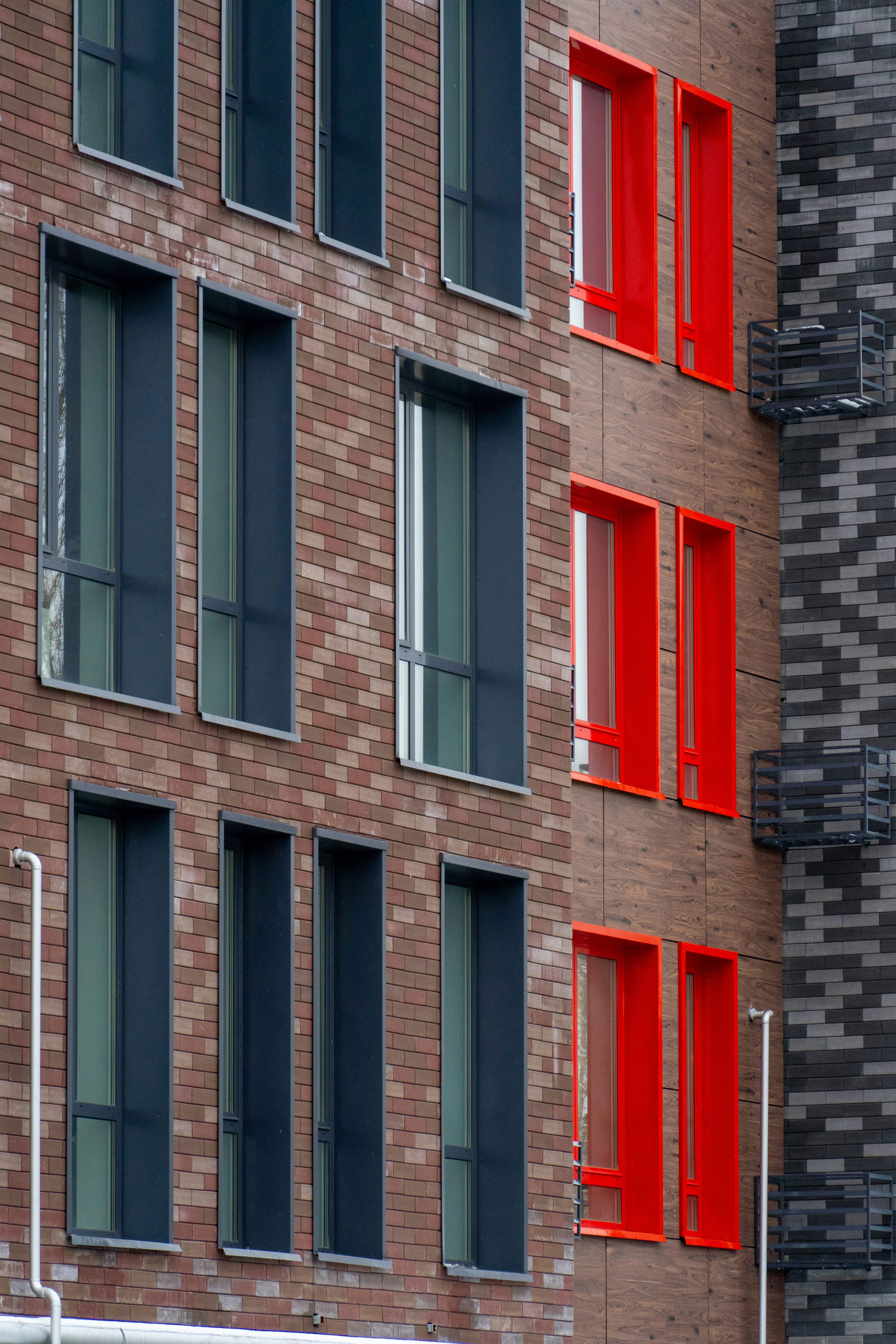 Foto Un edificio alto de ladrillo con ventanas rojas al lado de una ...