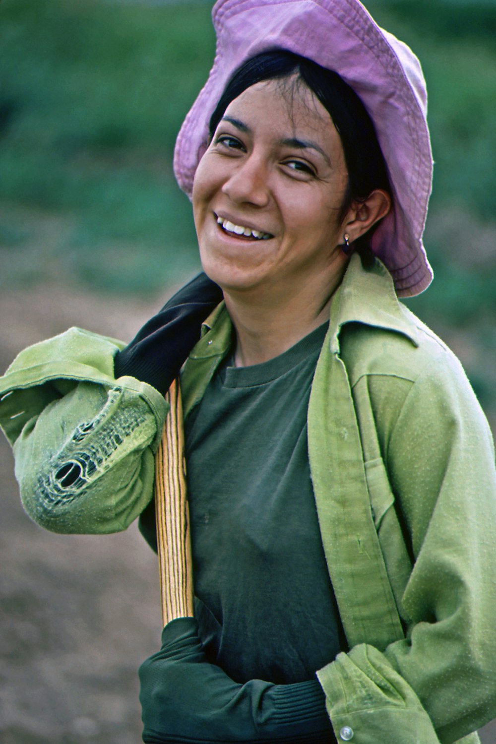 a woman wearing a purple hat and green jacket