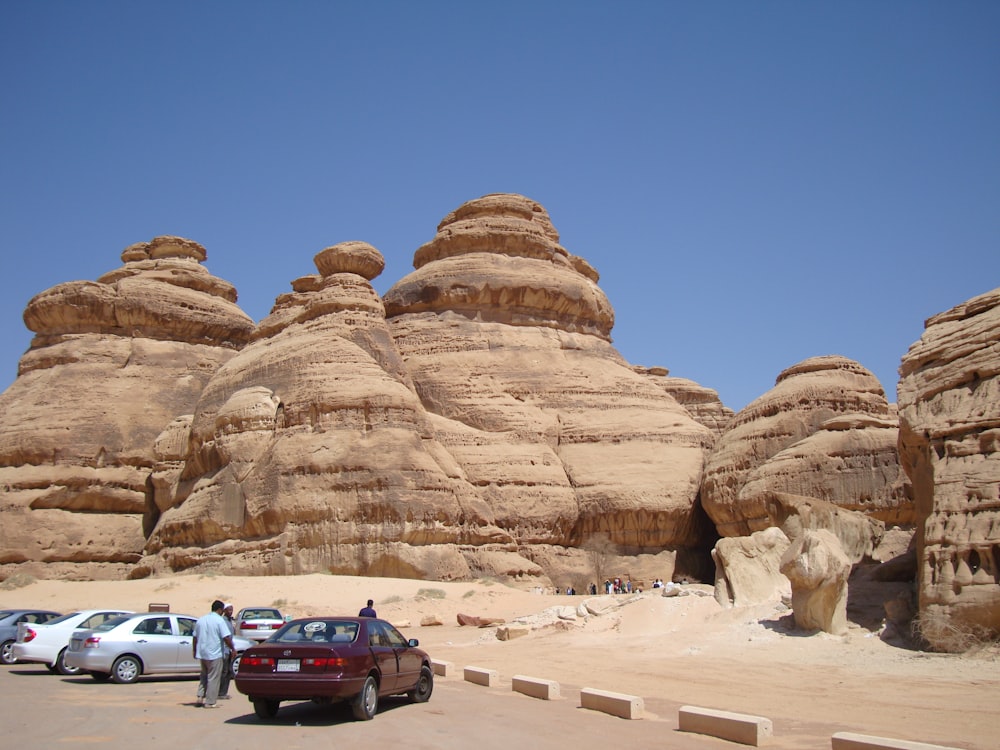 a group of cars parked in front of a rock formation