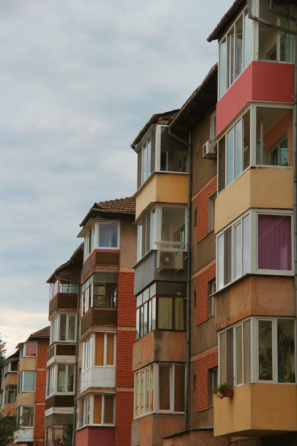 a row of multi - colored apartment buildings on a cloudy day