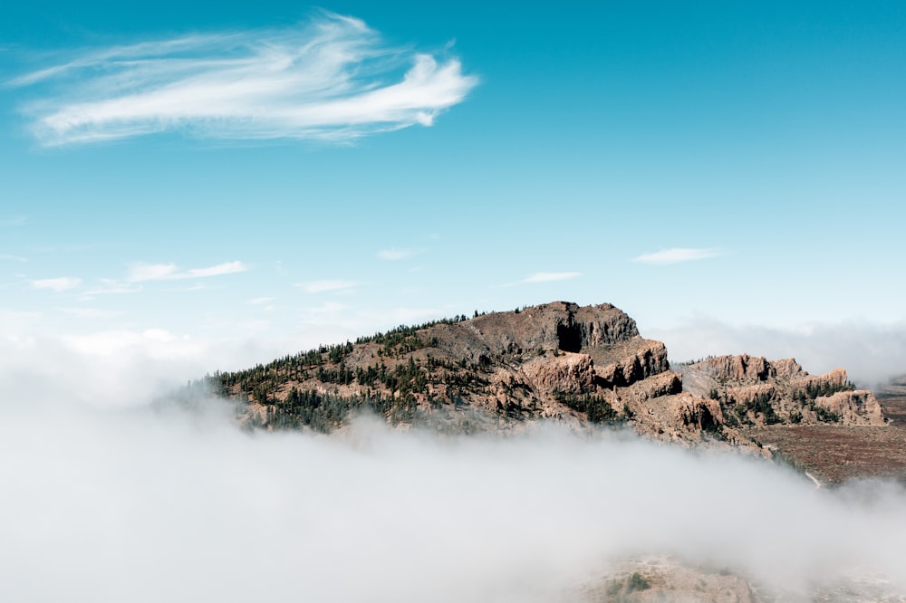 Une montagne couverte de nuages sous un ciel bleu