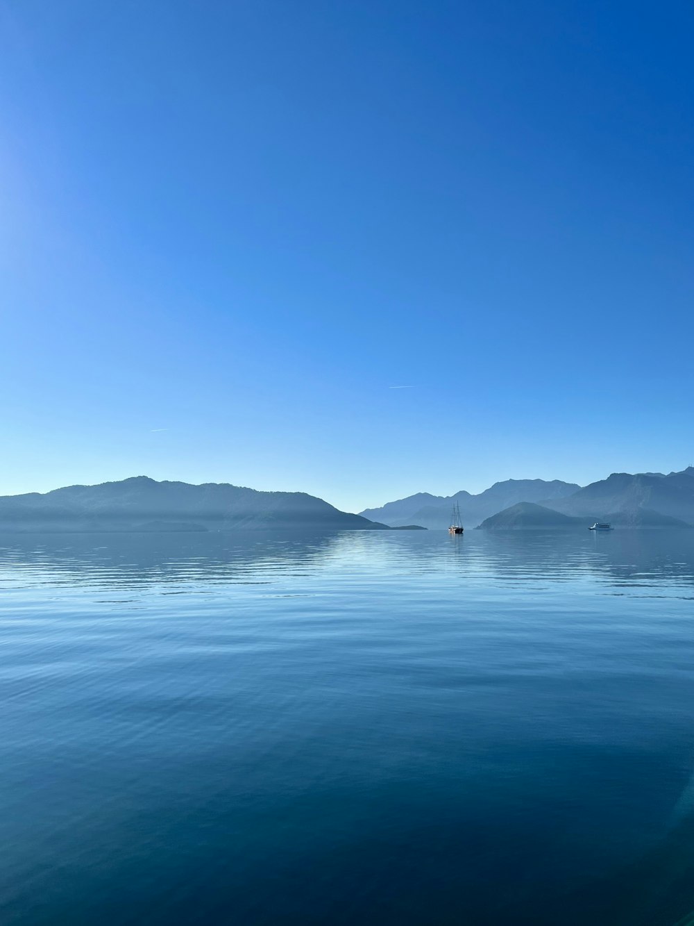 ein großes Gewässer mit Bergen im Hintergrund