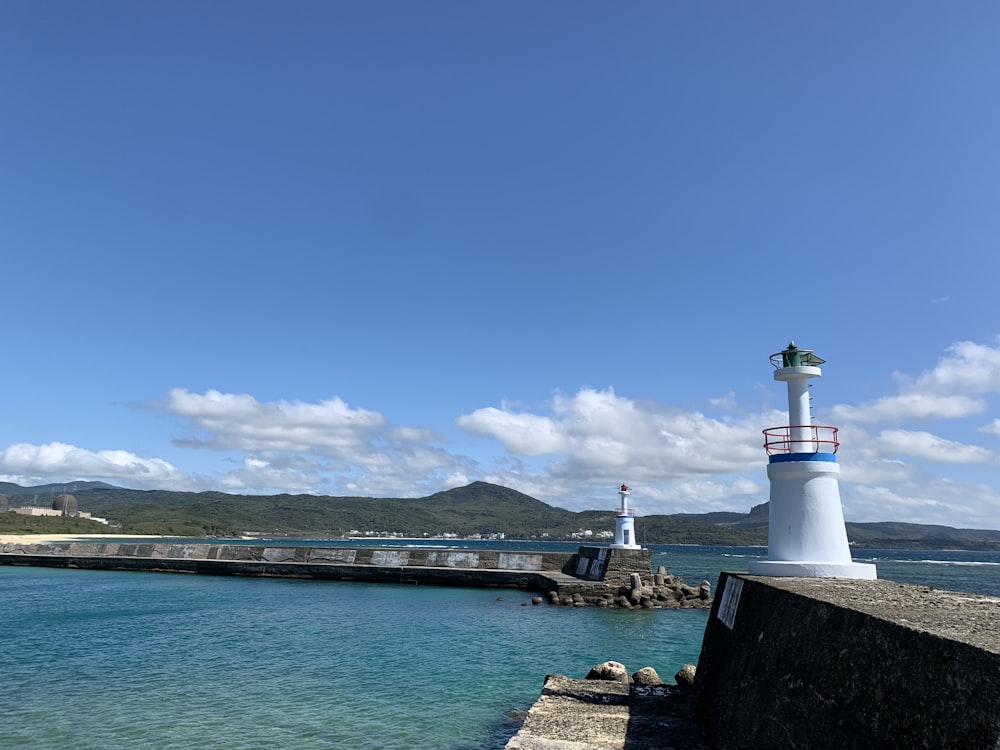 Ein Leuchtturm auf einem Pier neben dem Meer