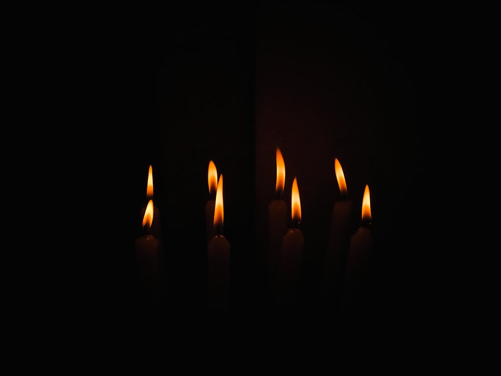 a group of lit candles in the dark