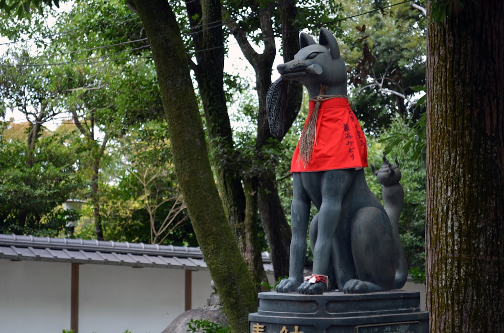 a statue of a dog and a cat in a park