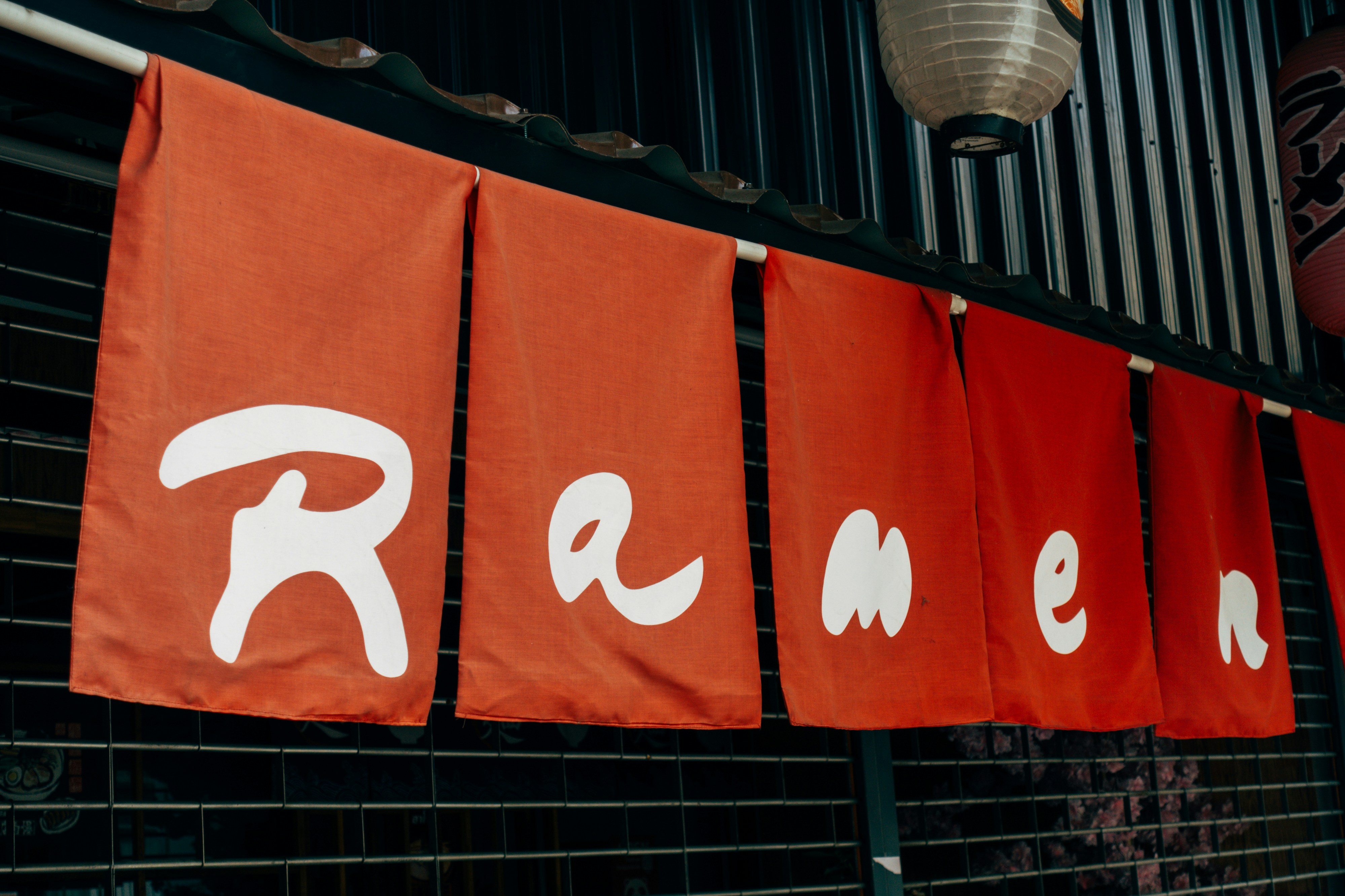 a row of red banners hanging from the side of a building