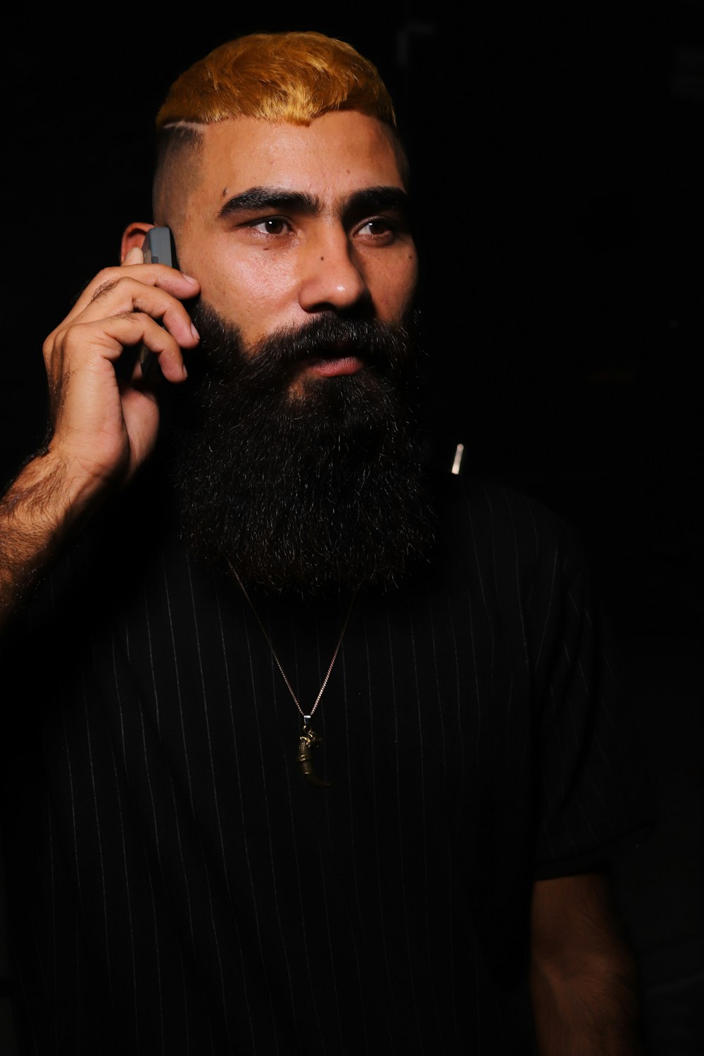 a man with a beard talking on a cell phone
