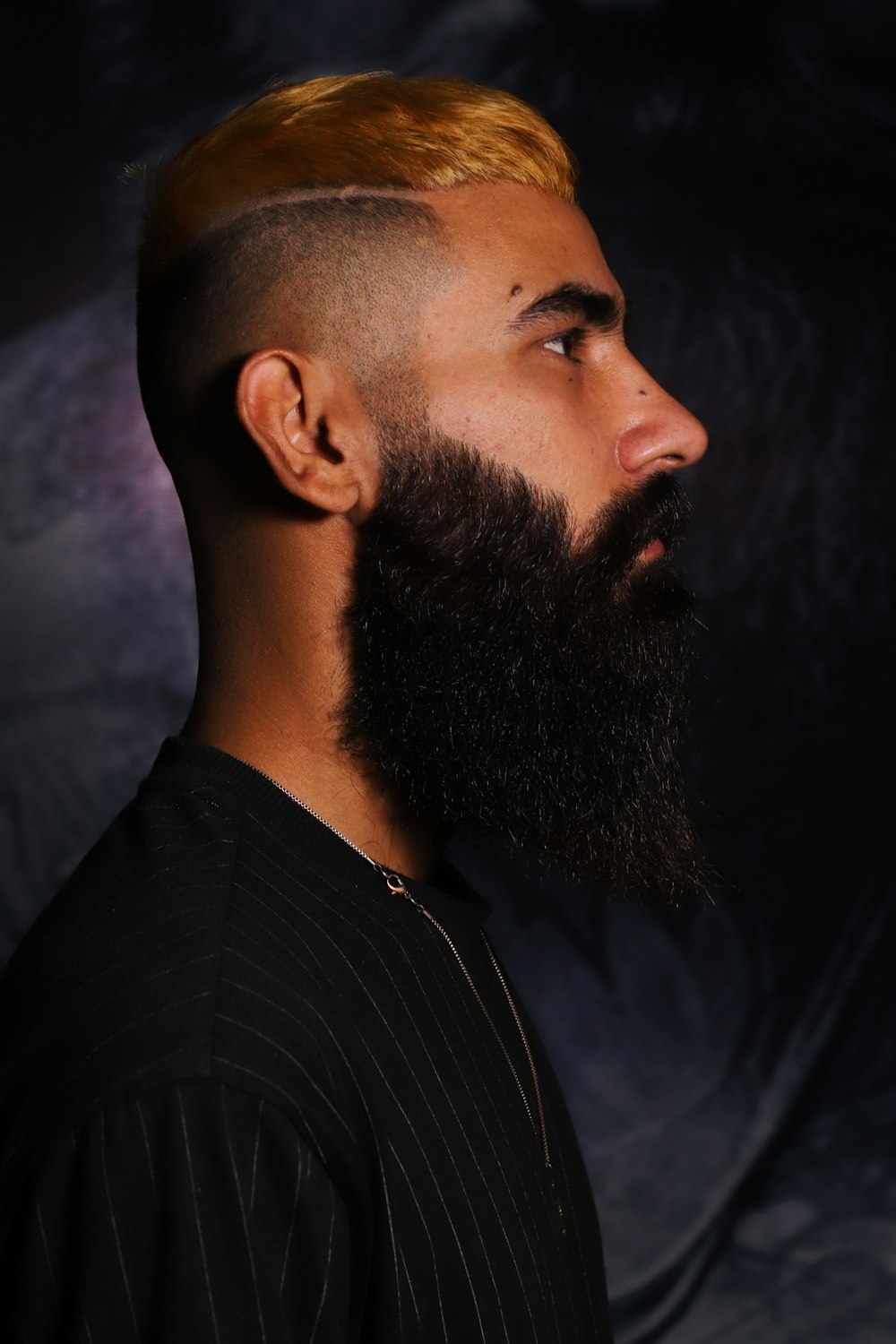 a man with a long beard and a shaved undercut
