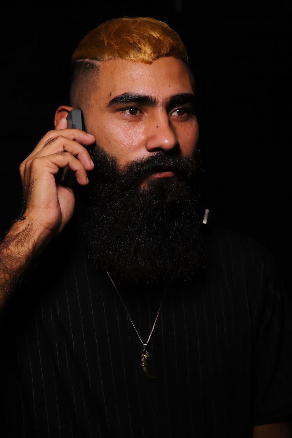 a man with a beard talking on a cell phone