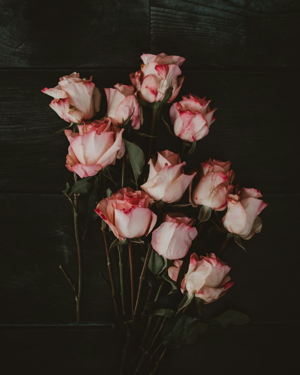 a bunch of pink roses sitting on top of a table