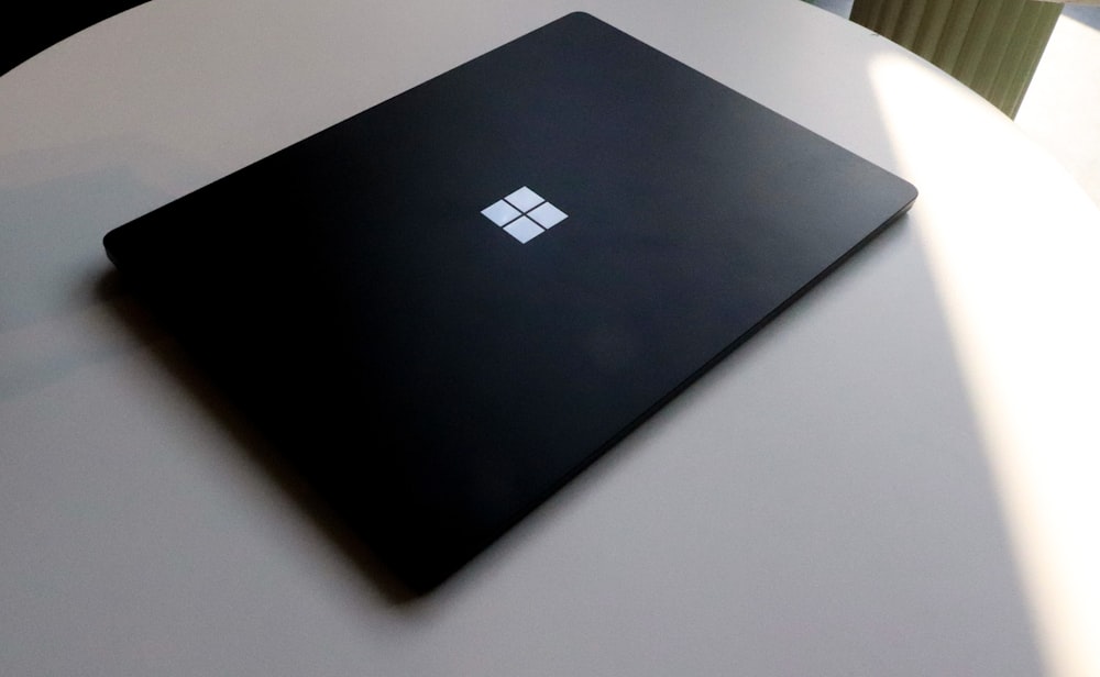 a laptop computer sitting on top of a white table