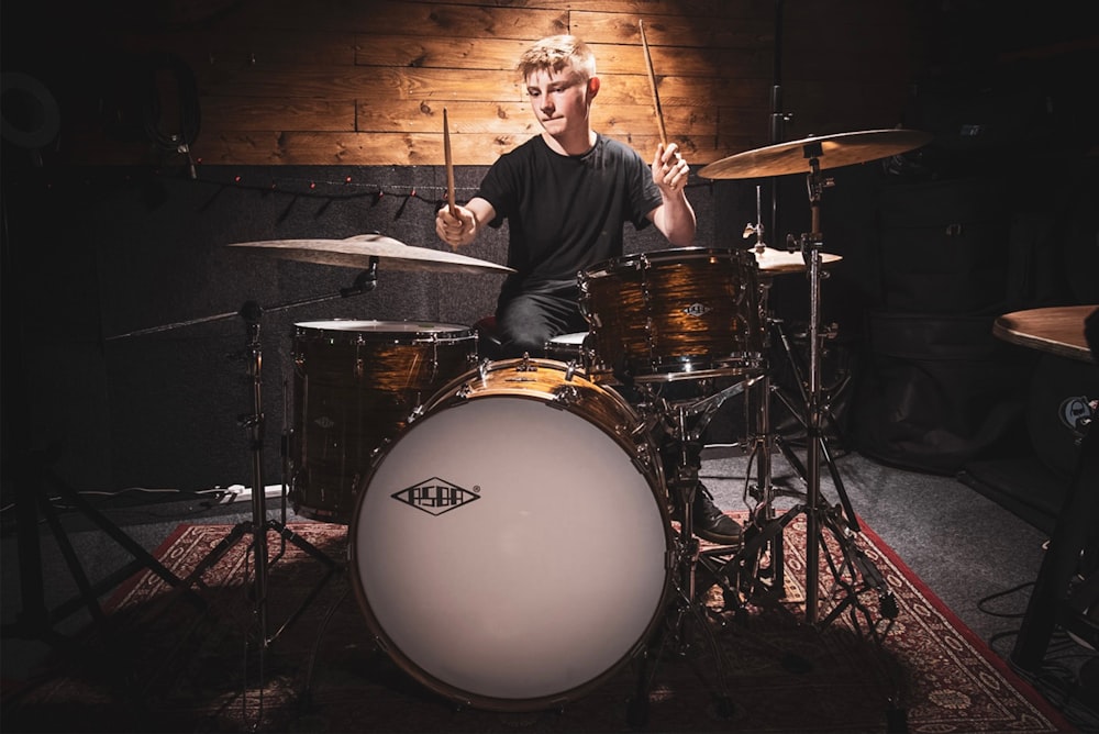 a man sitting in front of a drum set