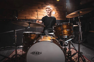 a man sitting on top of a drum set