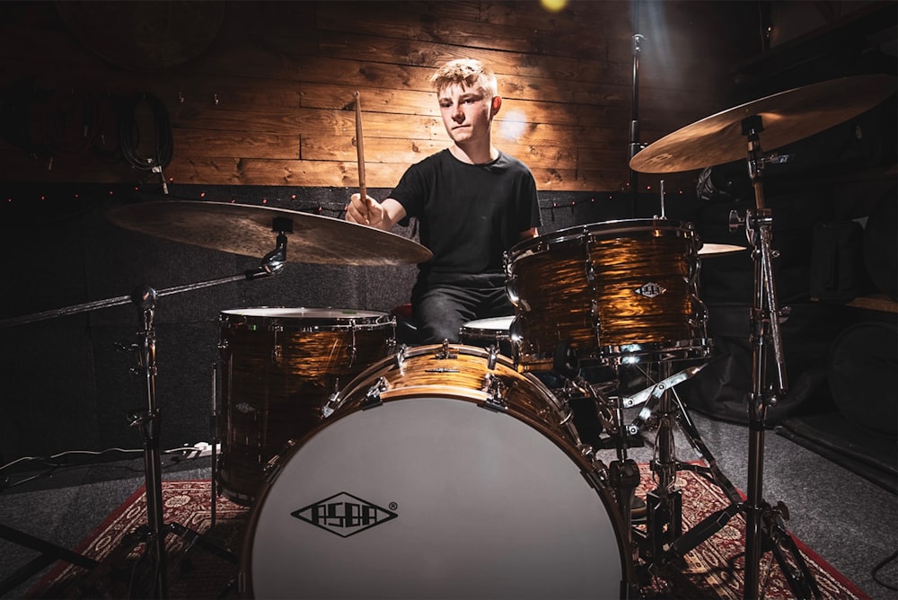 a man sitting on top of a drum set