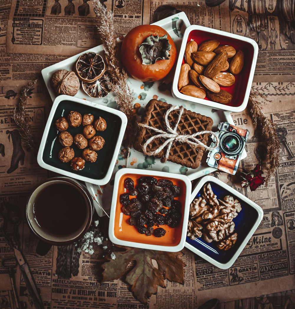 a table topped with trays of food next to a cup of coffee