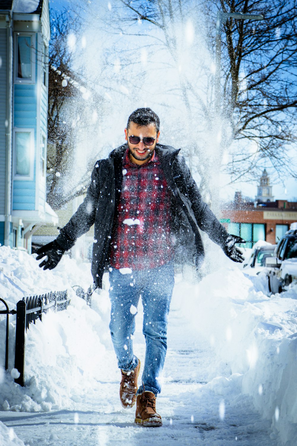 a man walking down a street covered in snow