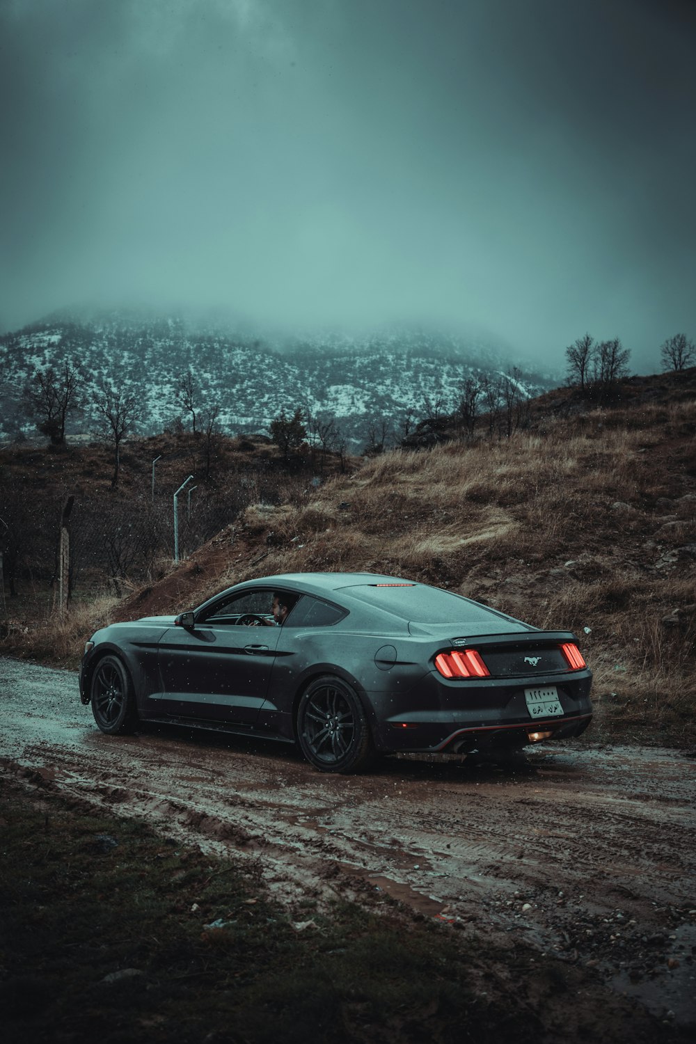 a black sports car parked on a dirt road