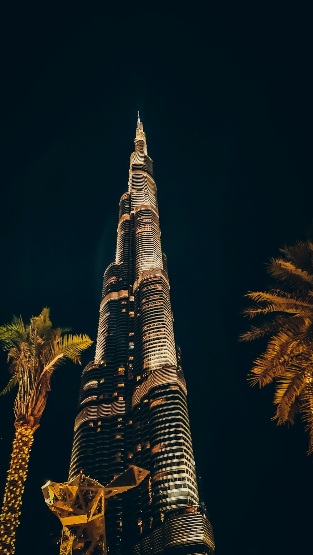 the burj tower is lit up at night