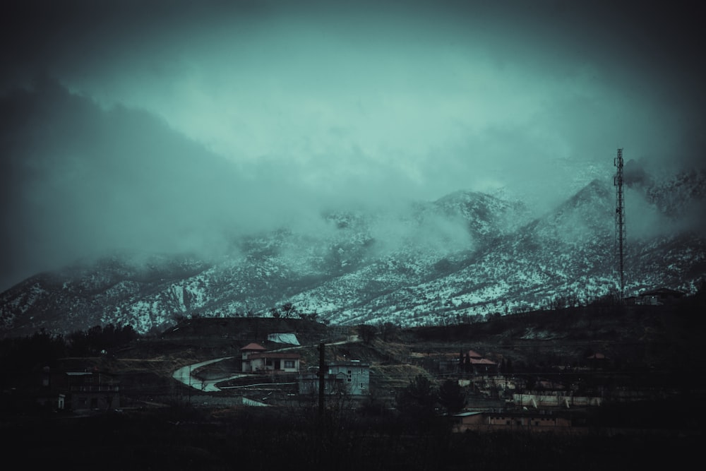 a mountain covered in snow with a telephone pole in the foreground