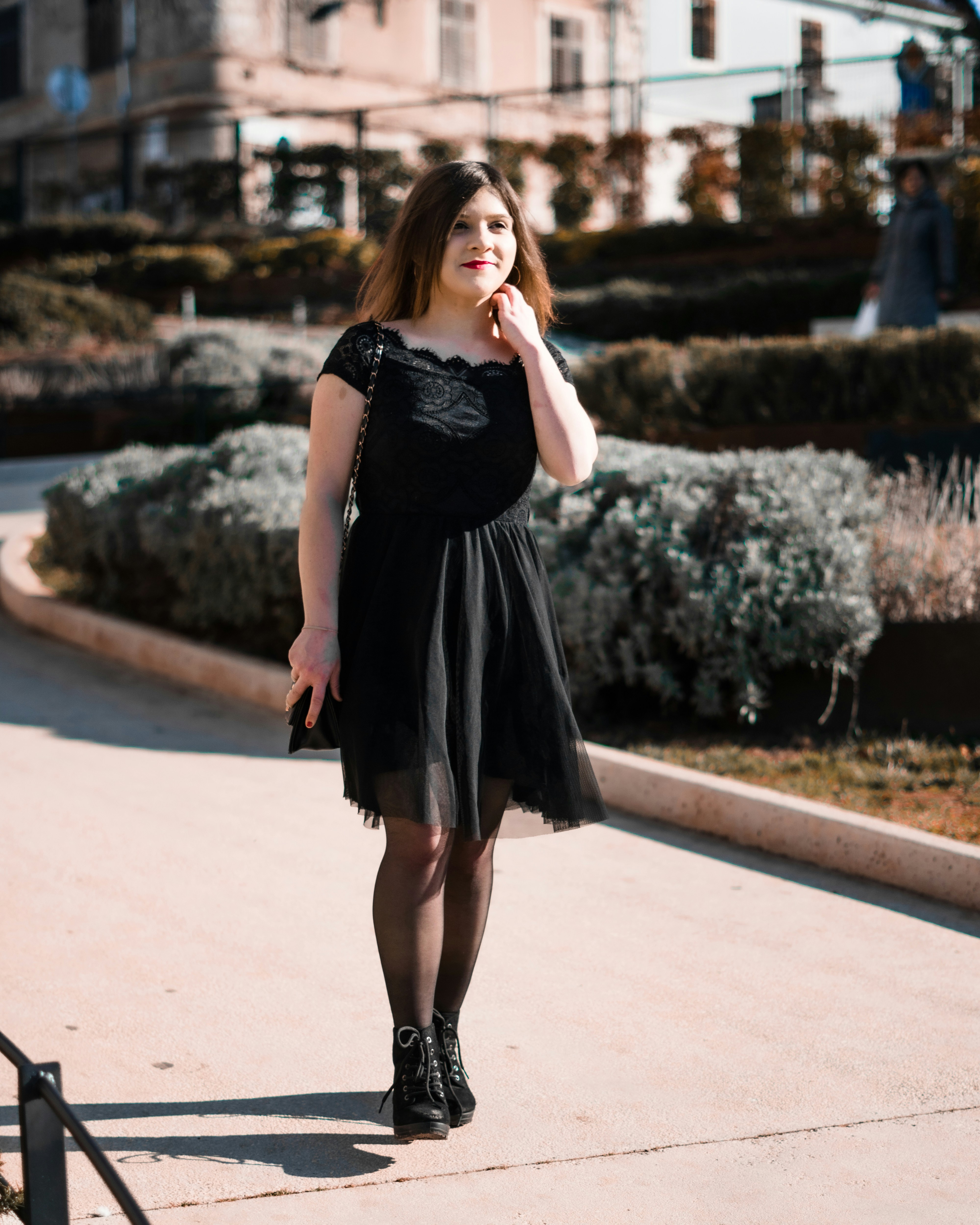 A woman in a black dress walking down a sidewalk photo – Free Hrvatska ...