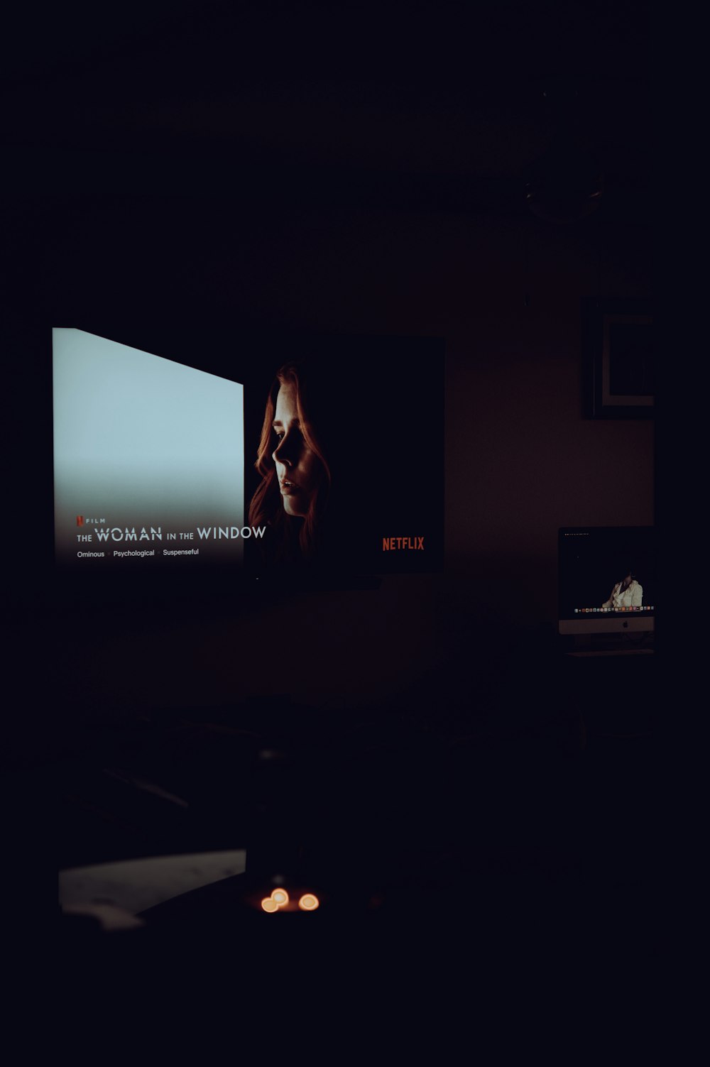 a dark room with a large screen on the wall