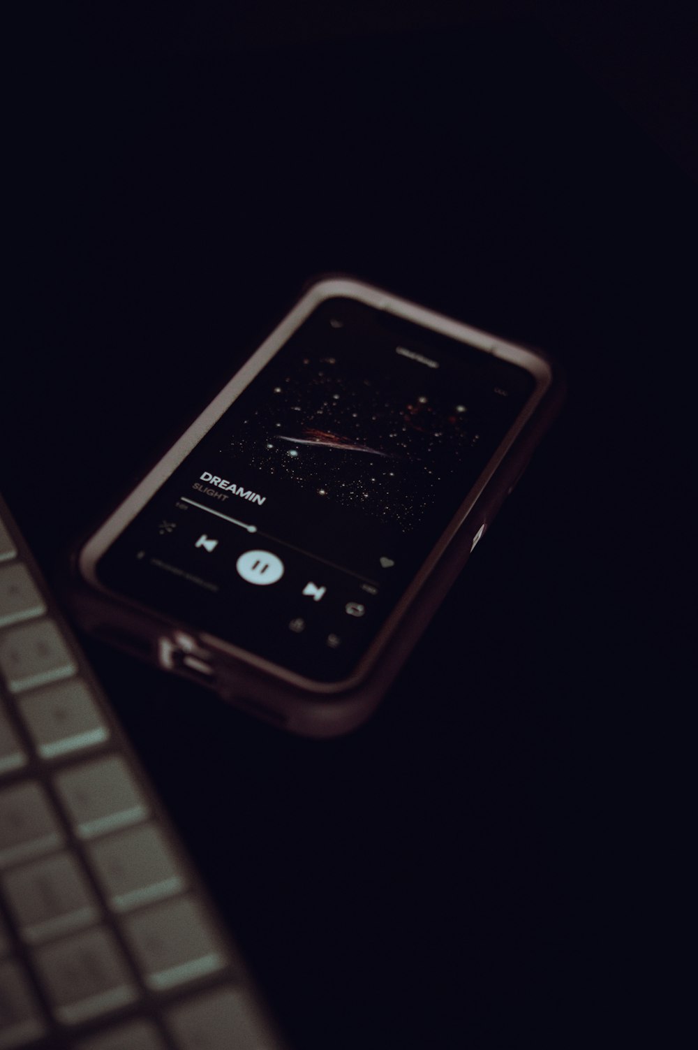 a cell phone sitting next to a keyboard