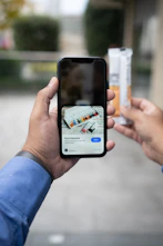 a person taking a picture of a cigarette with a cell phone