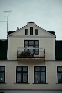 a tall white building with a balcony and balconies