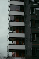 Modern residential building with dark sleek design, reflecting sophistication.