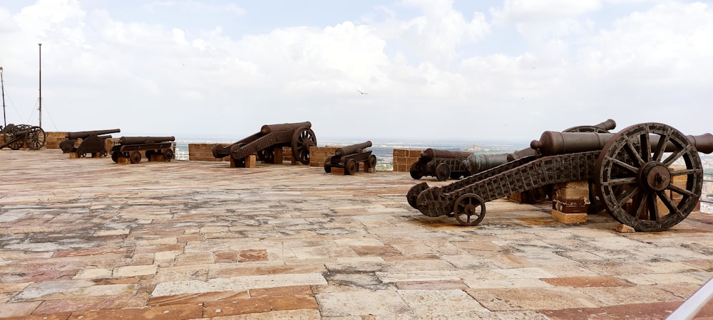 a group of old cannon on a stone floor
