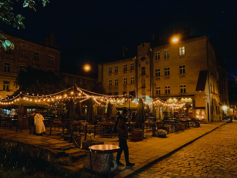 Un homme debout devant un immeuble la nuit