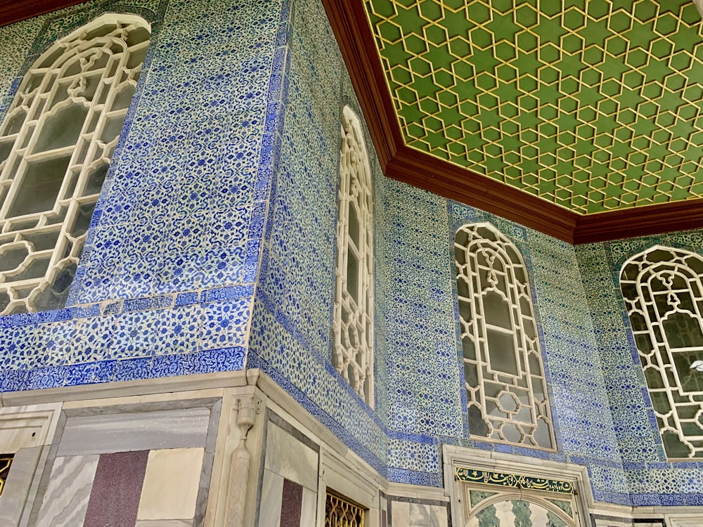a room with blue and white tiles and a green ceiling