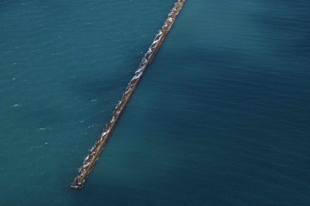 an aerial view of a long pier in the middle of the ocean