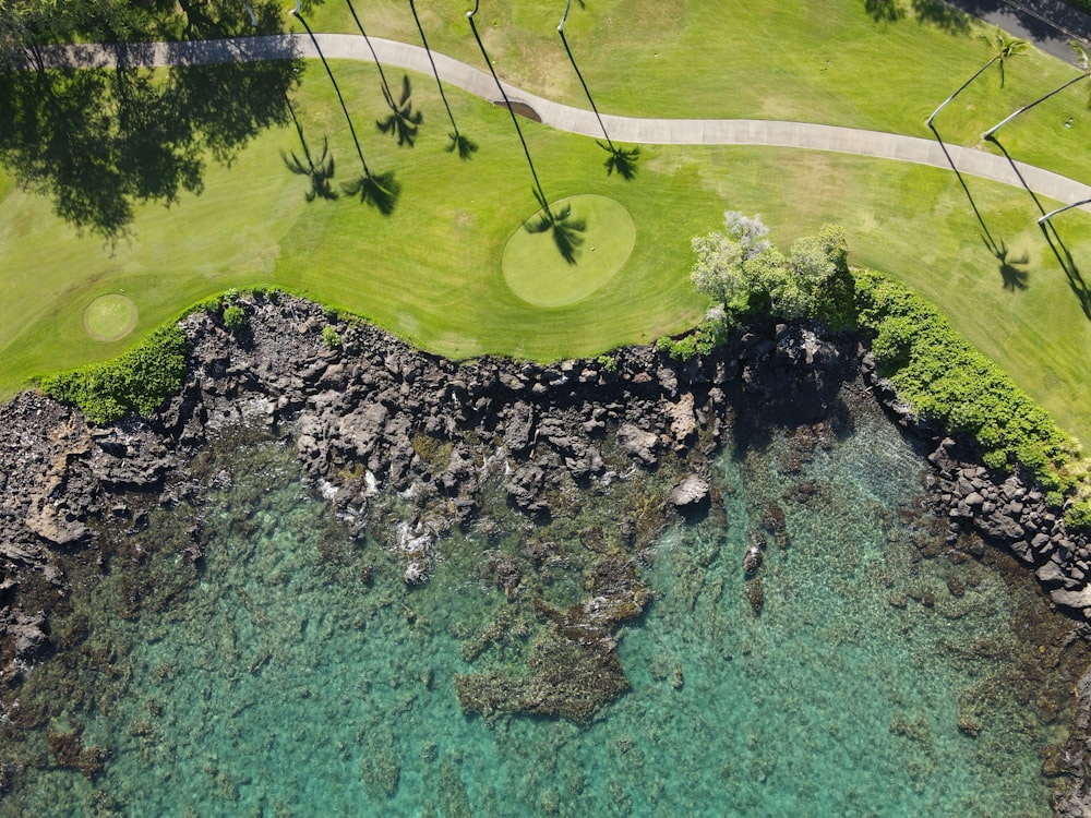 an aerial view of a golf course and water