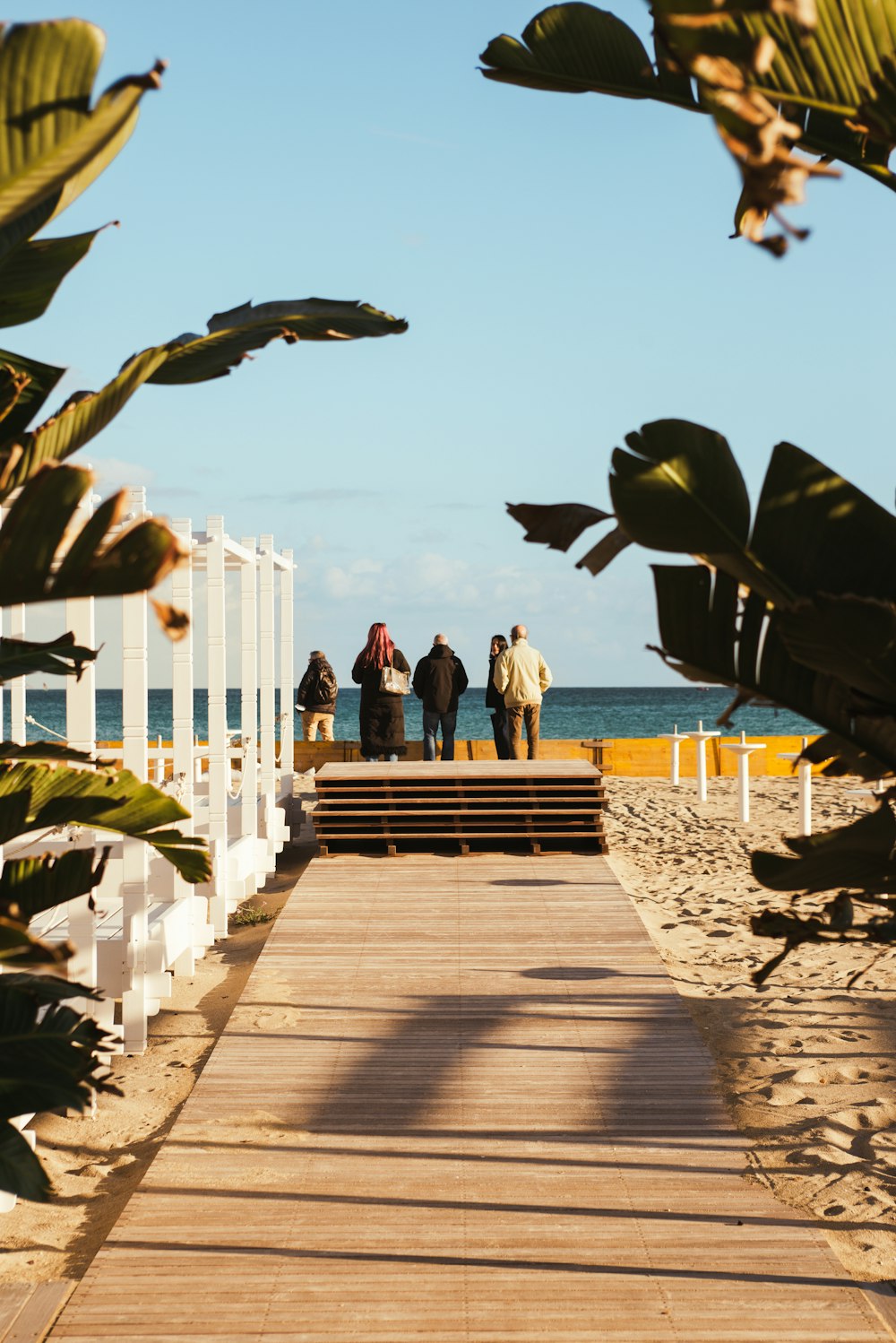 a group of people standing on top of a wooden walkway