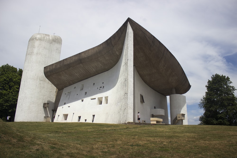 a white building with a curved roof on top of a hill