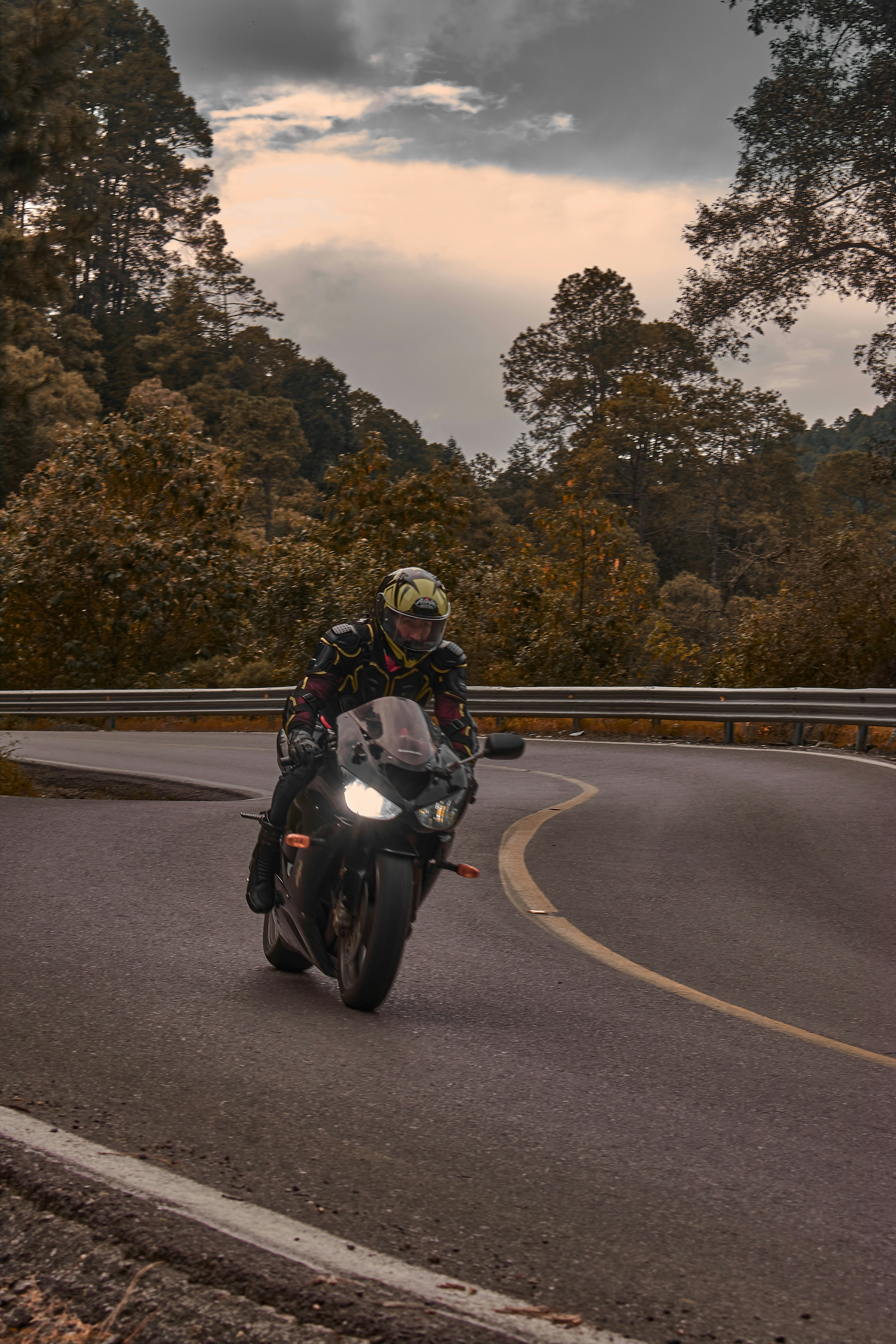 a man riding a motorcycle down a curvy road