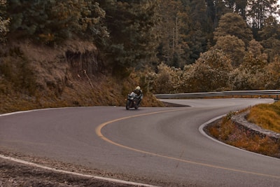 A scenic shot of a rider navigating a winding mountain road.