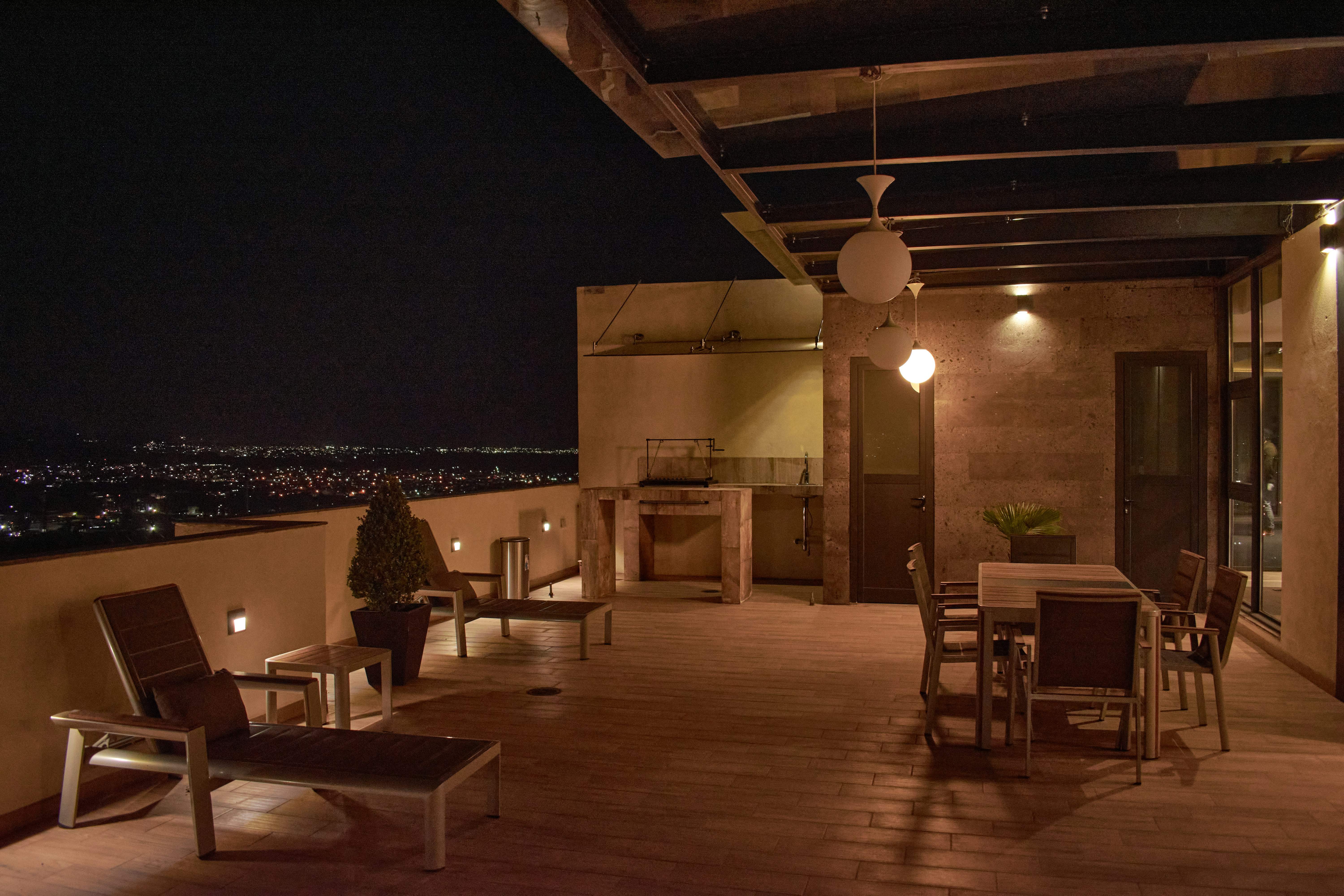 a balcony with a table and chairs and lights