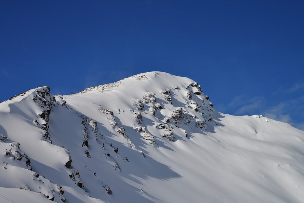 a mountain covered in snow under a blue sky