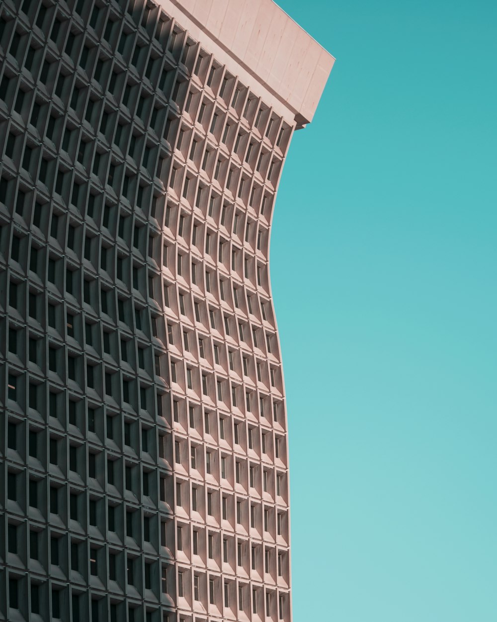 a plane flying in the sky next to a tall building