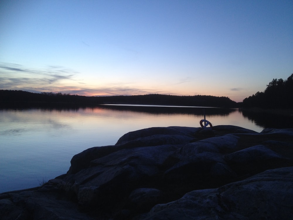 a person standing on a rock near a body of water