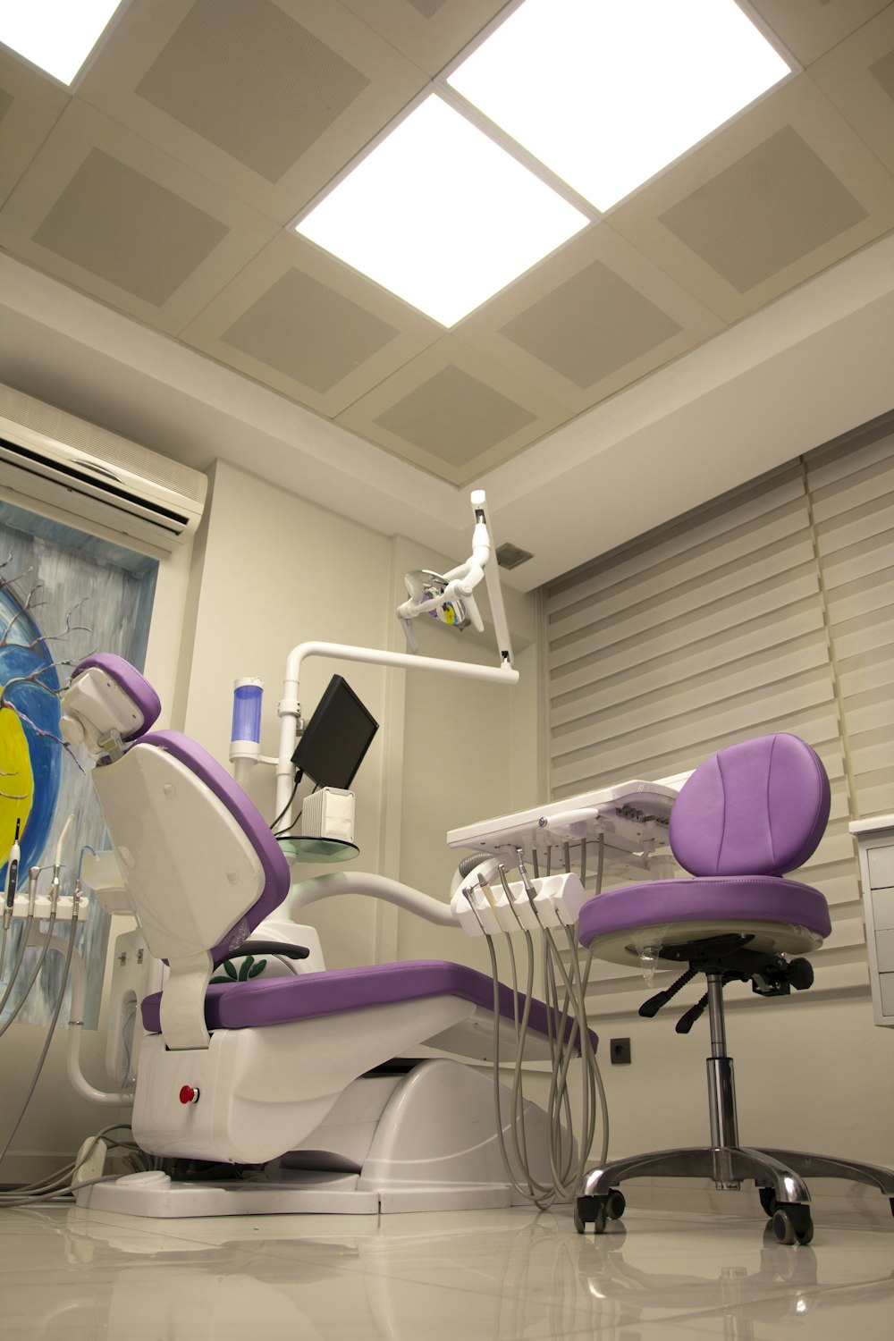 un fauteuil de dentiste dans une pièce avec un puits de lumière
